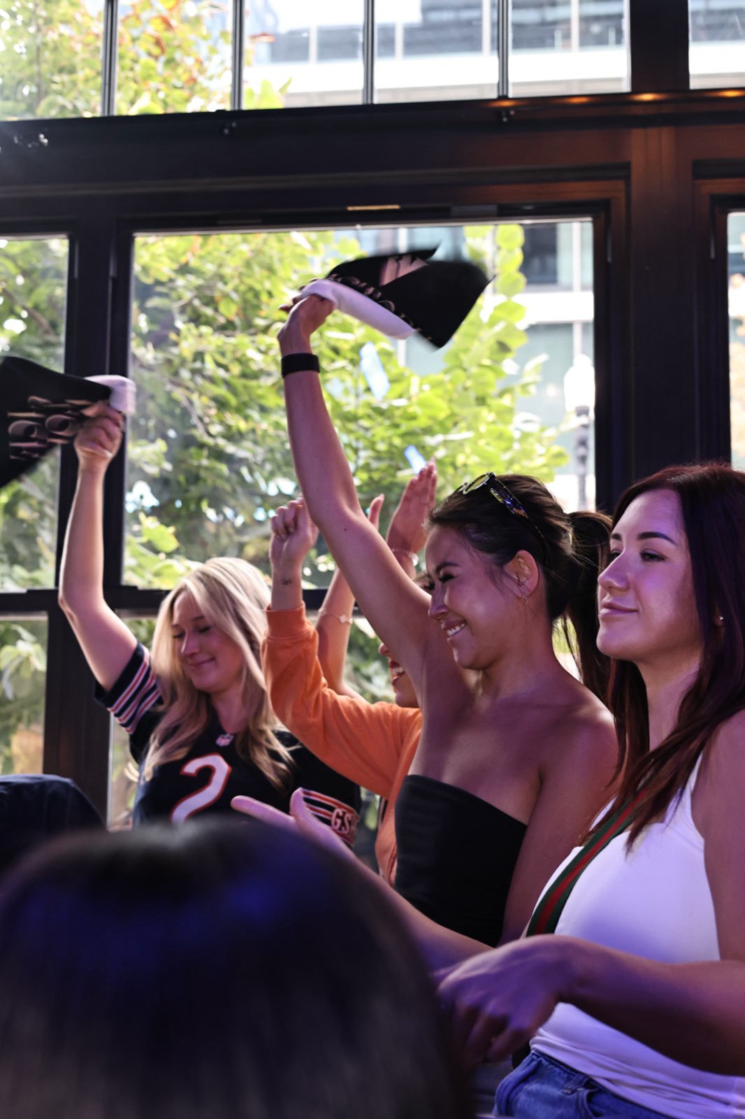 Guests on their feet with towels up, watching the game through the front windows.
